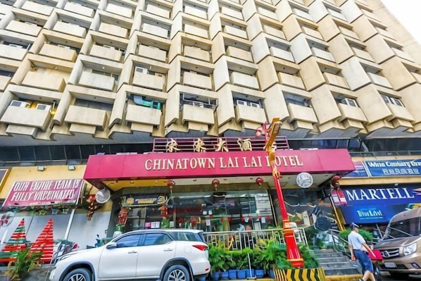 A hotel with a distinctive facade, a sign for the Chinatown Lai Lai Hotel, and a visible storefront with a sign for a vaccination service. - Chinatown Lai Lai Hotel Manila (City of Manila)