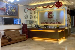 A hotel reception area with a reception desk, a sofa, and a wall-mounted television. - Chinatown Lai Lai Hotel Manila (City of Manila)