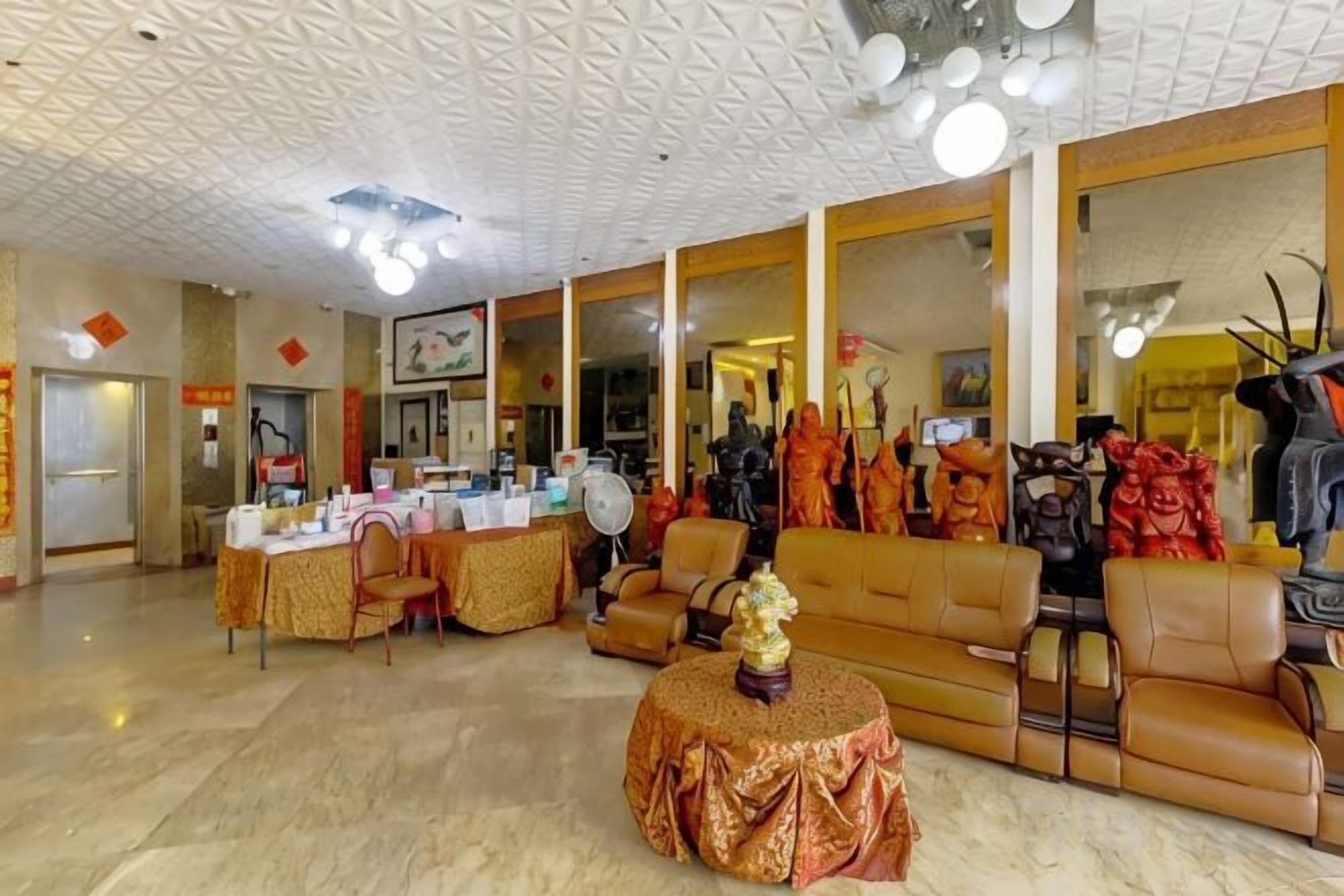 A hotel lobby with a reception desk, seating area, and a display of clothing.