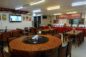 A hotel dining area with round tables, chairs, and a buffet setup. - Chinatown Lai Lai Hotel Manila (City of Manila)