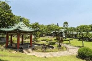 A traditional pavilion with a tiled roof, surrounded by a well-maintained garden with palm trees and a clear sky. - Chinatown Lai Lai Hotel Manila (City of Manila)