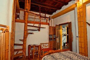Una habitación rústica con una escalera de madera, una cama con estampado de cebra y una silla de madera.