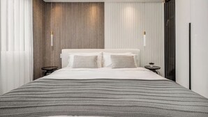 A modern hotel room with a large bed, a bedside table, and a small table with a plant. - delite* Elite Heaven:Luxurious1Bed+1bath (Medellín)