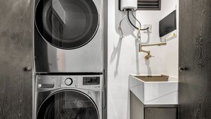 A compact laundry room with a washing machine, dryer, and a sink with a gold faucet. - delite* Elite Heaven:Luxurious1Bed+1bath (Medellín)
