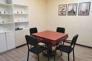 A room with a red table, four black chairs, a white shelving unit with decorative items, and three framed pictures on the wall. - Junyi Chain Hotel (Tianmen baoan palza Store) (Tianmen)