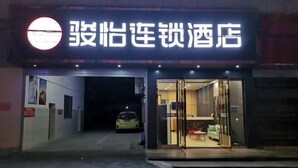A hotel entrance with a sign in Chinese characters, a reception desk, and a car parked outside. - Junyi Chain Hotel (Tianmen baoan palza Store) (Tianmen)