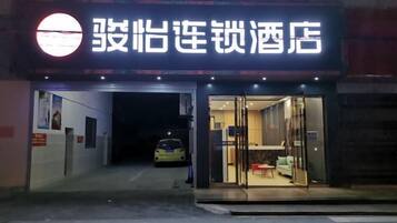A hotel entrance with a visible car parked outside.