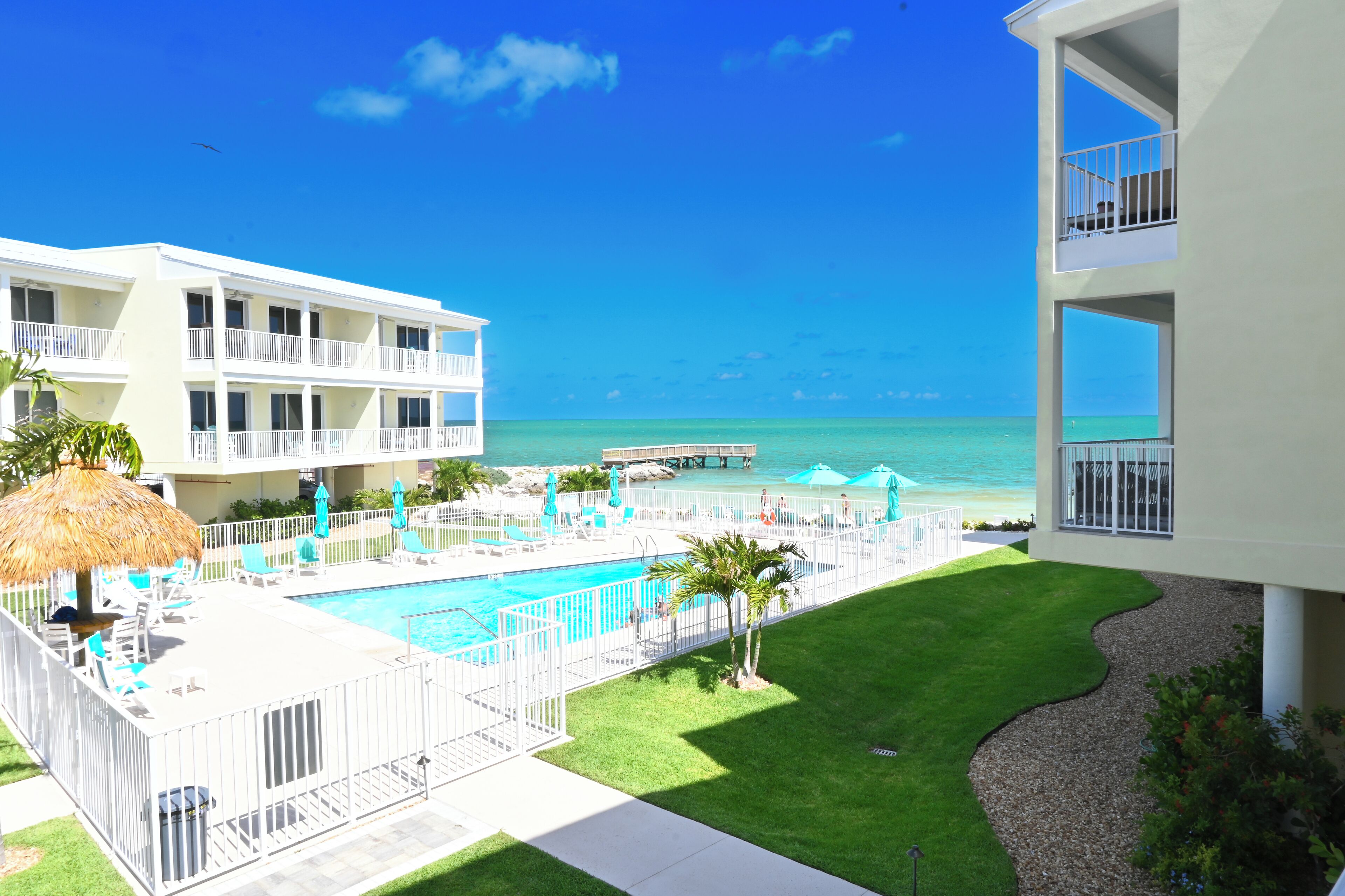 Un hôtel doté d’une piscine, offrant une vue sur l’océan et comprenant une jetée.