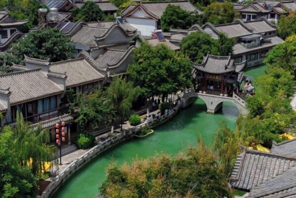 A traditional Chinese courtyard with a bridge, surrounded by buildings with tiled roofs. - JP Hyllis Hotel (Chuxiong City)