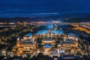 A large, traditional building with multiple levels and a prominent dome structure, surrounded by a well-lit urban area. - JP Hyllis Hotel (Chuxiong City)
