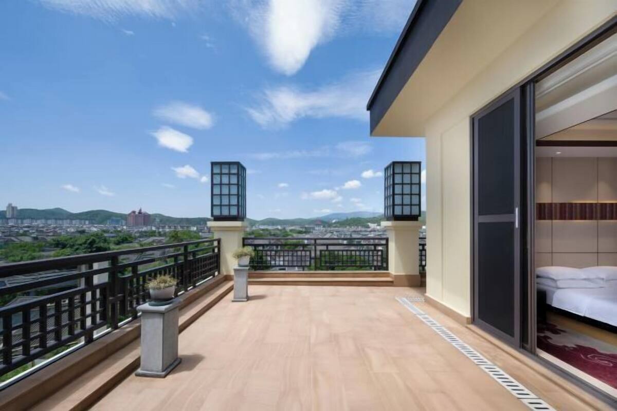 Ein Balkon mit Blick auf die Stadt, ein Bett und eine Schiebetür.
