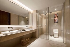 A modern bathroom with a large mirror, two sinks, a glass shower enclosure, and a toilet. - JP Hyllis Hotel (Chuxiong City)