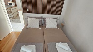 A double bed with two pillows and two folded towels. - Apartment Furdi - Two Bedroom Apartment with Terrace (Zaton)