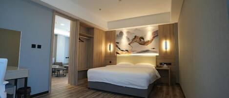 Una habitación de hotel moderna con una cama, una mesita de noche y una obra de arte colgada en la pared.