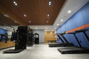 A gym with treadmills, a weight machine, and a bench. - Tianjing Hotel (Shenyang)