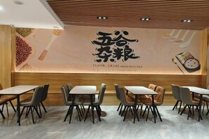 A restaurant interior with tables and chairs arranged for dining. - Tianjing Hotel (Shenyang)