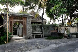 Un bâtiment en pierre avec une porte en bois, un banc et un mur en pierre.