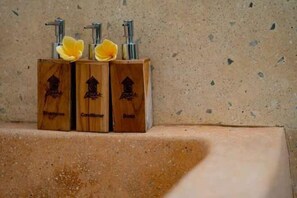 Three wooden dispensers labeled shampoo, conditioner, and soap on a countertop. - Gusde House and Villa Bali (Bali)
