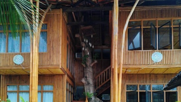 A wooden building with multiple floors, large windows, and a central staircase. - Casa Nena Hotel and Resort Iloilo (Miagao)