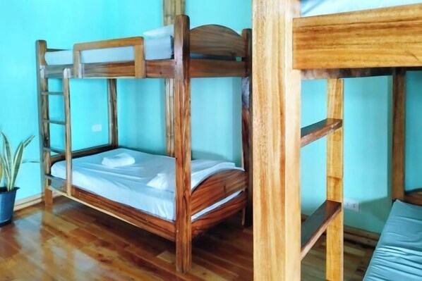 A bunk bed with a wooden frame and a mattress, a potted plant, and a wooden floor. - Casa Nena Hotel and Resort Iloilo (Miagao)