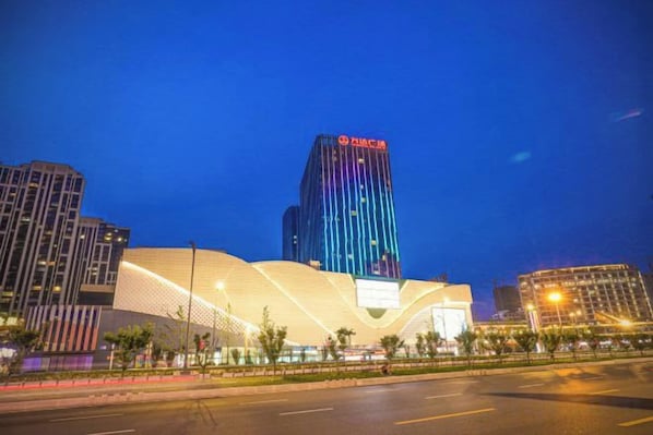 Un edificio moderno con una estructura vertical destacada y una fachada curva.