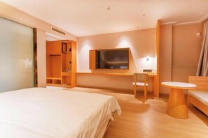 A hotel room with a bed, a desk, a chair, a TV, and a small table. - Tumeile Boutique Hotel (Yangzhou)