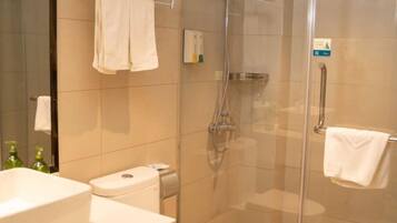 A bathroom with a glass-enclosed shower, a toilet, and a sink.