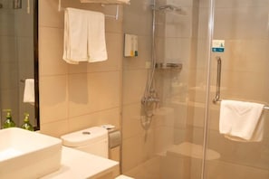 A bathroom with a glass-enclosed shower, a toilet, and a sink. - Tumeile Boutique Hotel (Yangzhou)