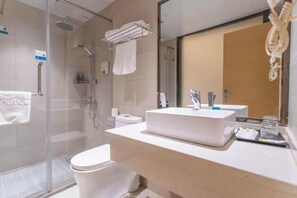 A modern bathroom with a glass shower enclosure, a white sink, and a toilet. - Tumeile Boutique Hotel (Yangzhou)