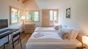 Une chambre avec deux lits, un bureau et une télévision.
