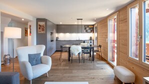 Un intérieur moderne comprenant un coin repas, une cuisine et de grandes fenêtres.