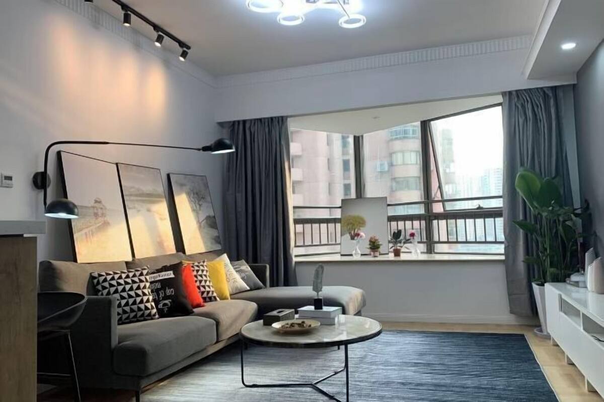 Ein modernes Wohnzimmer mit einer Couch, einem Couchtisch und Kunstwerken an der Wand.