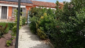 A house with a tiled roof, a gravel pathway, and various plants. - Clos des Plumbagos, between Avignon and the Ventoux (Monteux)
