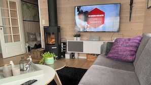 A cozy living room with a fireplace, a flat-screen TV, a sofa, and a coffee table. - Lovely and well equipped home with outdoor BBQ, ready for hiking in Seljestad. (Ullensvang)