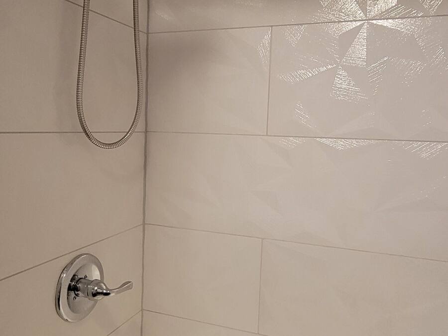 A bathroom with a bathtub, a showerhead, and a faucet.
