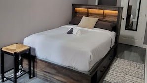 Una camera da letto con un letto, un comodino e uno specchio a parete.
