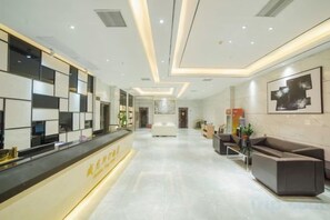 A hotel reception area with a reception desk, seating area, and a hallway leading to the rooms. - Baise Changle Business Hotel (Baise)