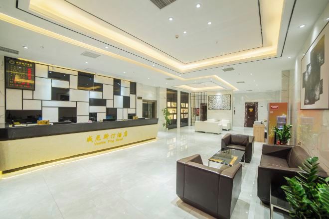 Un moderno vestíbulo de hotel con mostrador de recepción, zona de estar y detalles decorativos.
