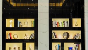 Two black shelving units with illuminated compartments displaying books, decorative items, and small sculptures. - Baise Changle Business Hotel (Baise)
