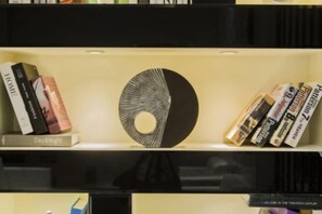 A bookshelf with books and a decorative object. - Baise Changle Business Hotel (Baise)