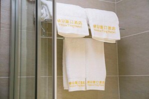 Zwei weiße Handtücher hängen an einem Wäscheständer, auf dem der Text 'Venice Ting Hotel' in Gelb zu sehen ist.