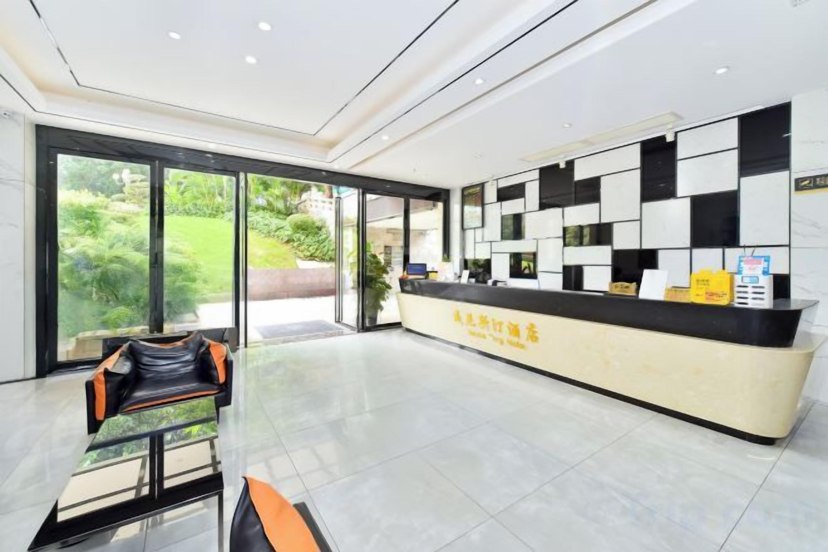 A reception area with a check-in counter, a seating area with chairs, and a view through the glass doors.