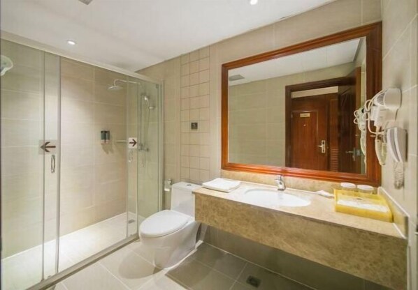 A modern bathroom with a glass-enclosed shower, a toilet, and a sink with a large mirror above. - Baise Changle Business Hotel (Baise)