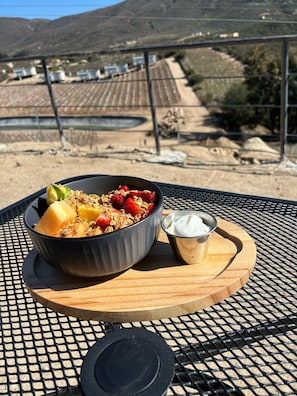 A meal on a table with a view of a vineyard and mountains in the background. - Castillo Toscana Hotel Boutique (Valle de Guadalupe)