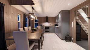 Una cocina moderna con muebles de madera, un comedor con una mesa larga y sillas, y una escalera que sube a un nivel superior.