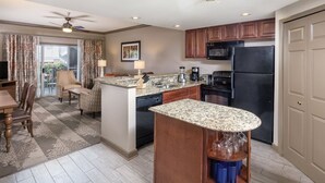 A modern kitchen with granite countertops, a black refrigerator, and wooden cabinets. - Discover the Heart of Music City at Wyndham Nashville – 2 Bd. Dxl-Family Getaway (Nashville)