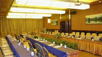 Une salle de conférence équipée d’une longue table, de chaises et d’un écran de projection.