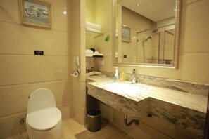 A bathroom with a toilet, a sink with a marble countertop, a mirror, and a trash can. - Ruijin Hotel (Dabu)