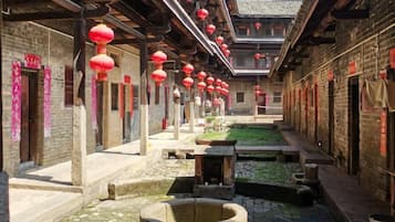 A courtyard with traditional architecture, stone lanterns, and a water feature.