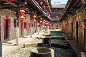 A courtyard with traditional architecture, stone lanterns, and a water feature. - Ruijin Hotel (Dabu)